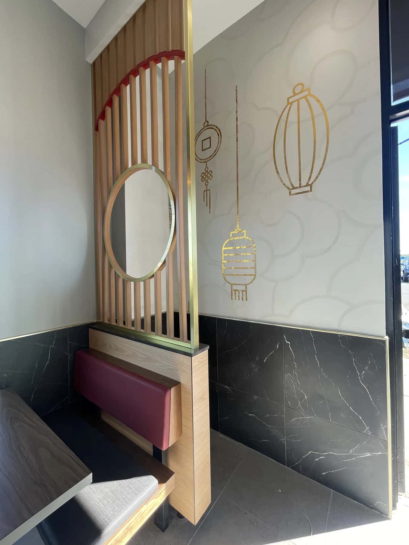 Detail of gold lantern wallcovering and wood slats in a restaurant booth