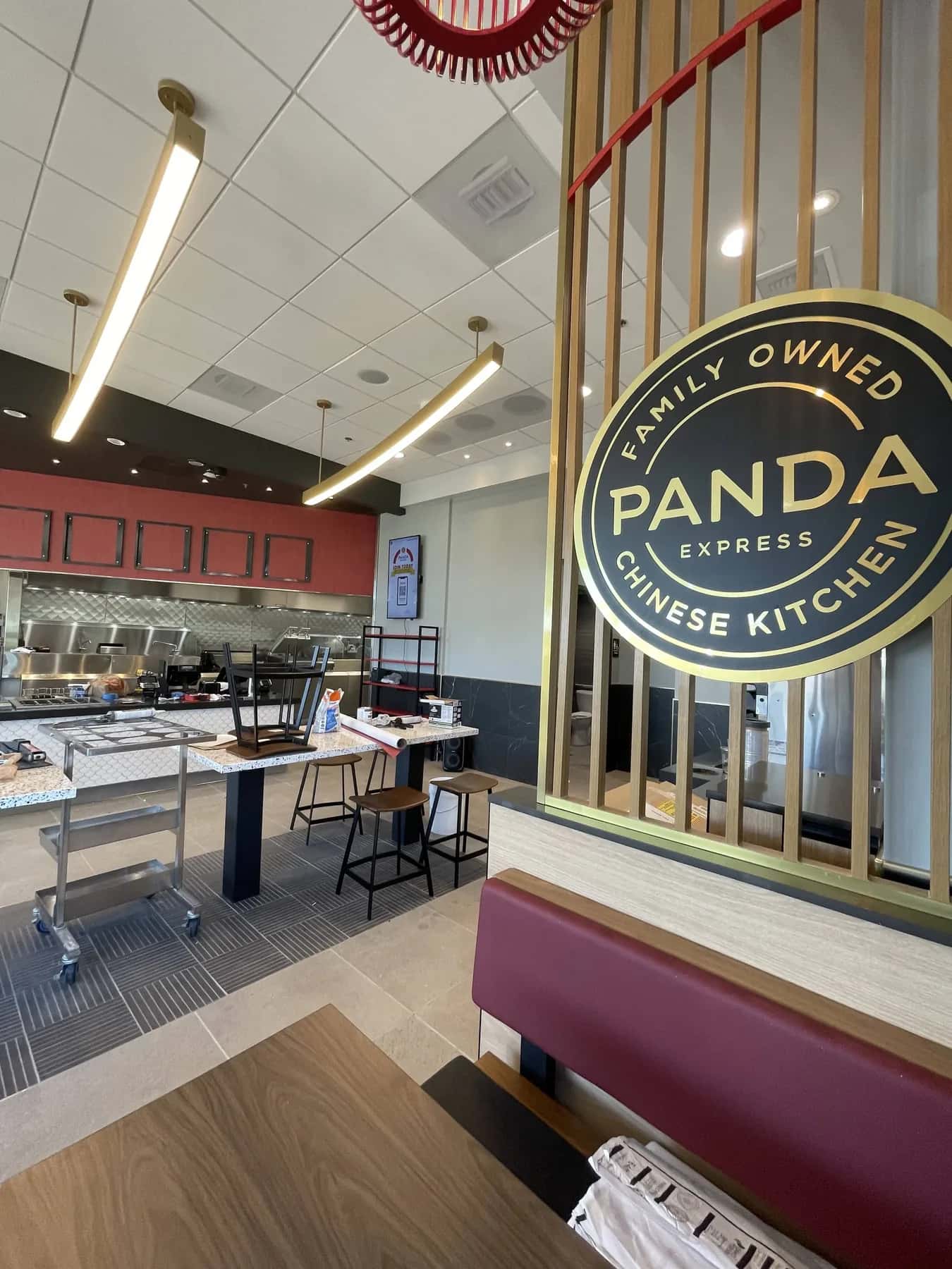 Wallcovering and marble wainscot beside the branded partition of a Panda Express dining room