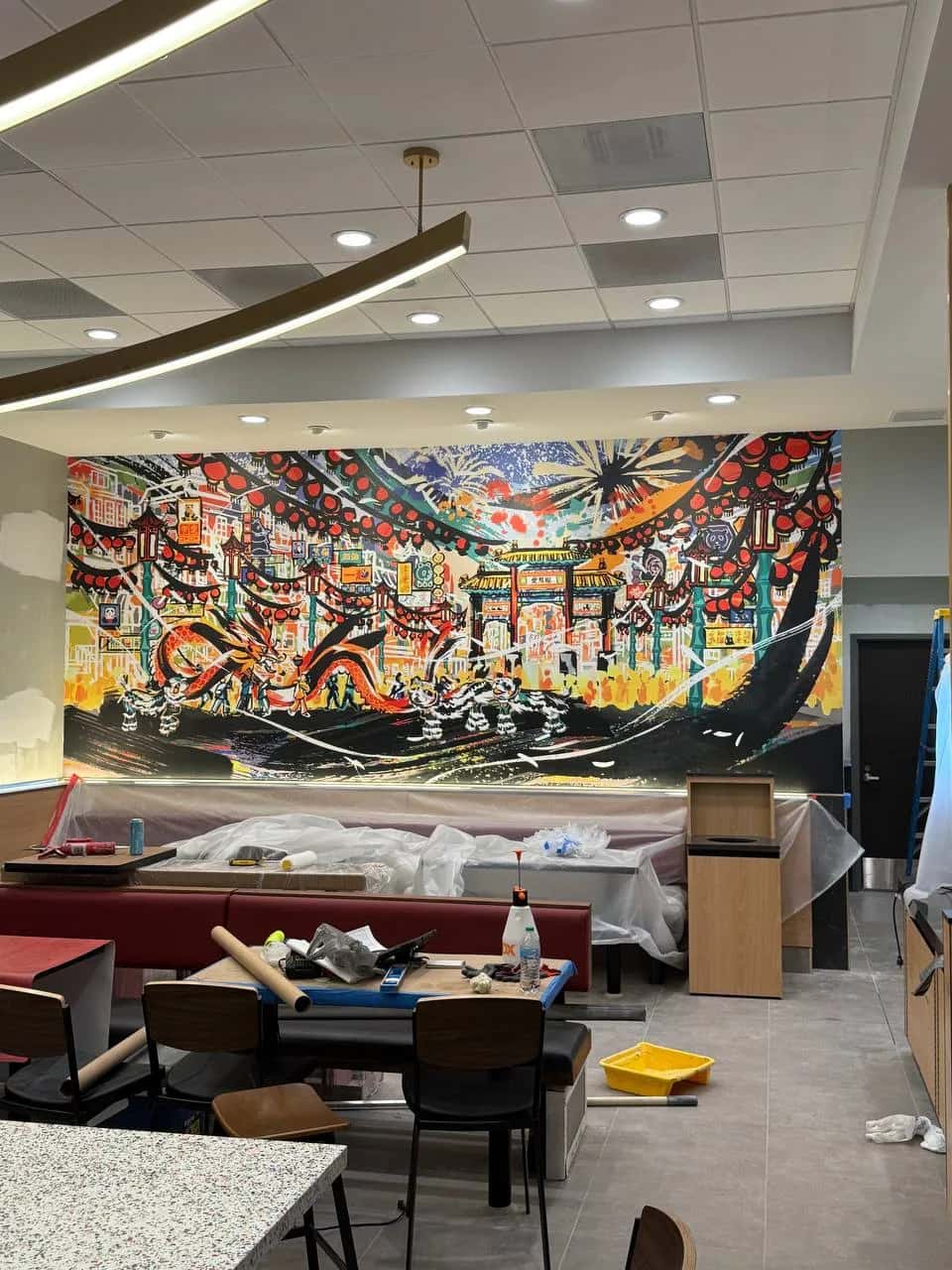Printed mural wallcovering above banquette seating in a restaurant