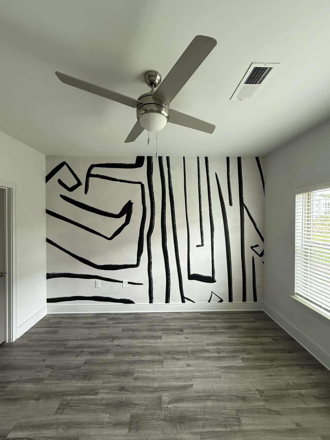 Black line-drawing mural covering a living room wall