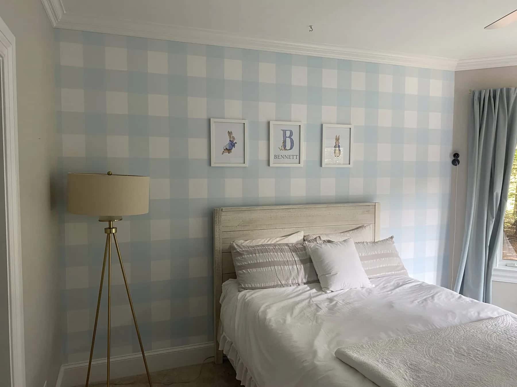 Soft blue plaid wallpaper behind a bed in a Charlotte bedroom