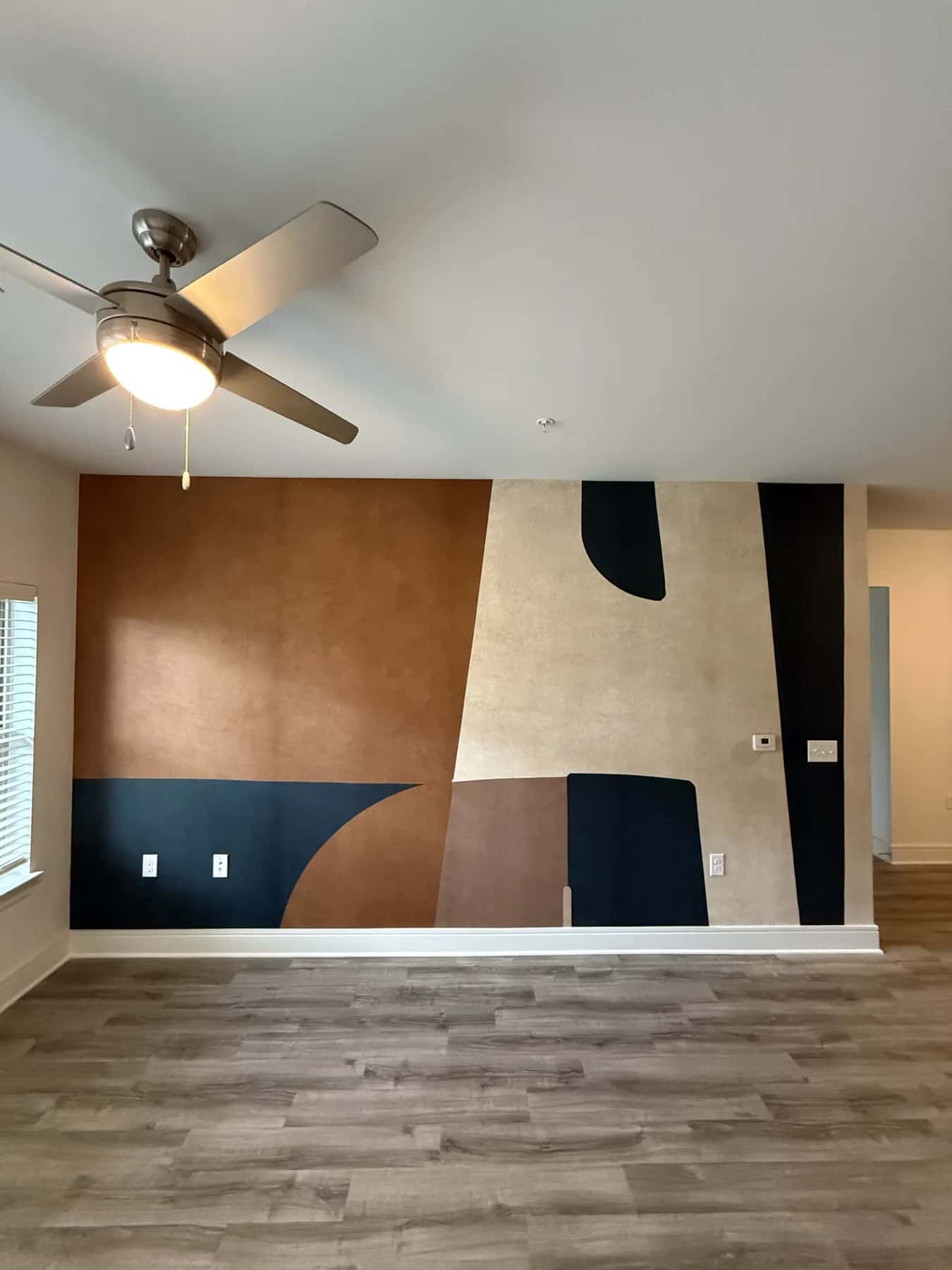 Terracotta, navy and cream geometric mural covering a living room wall