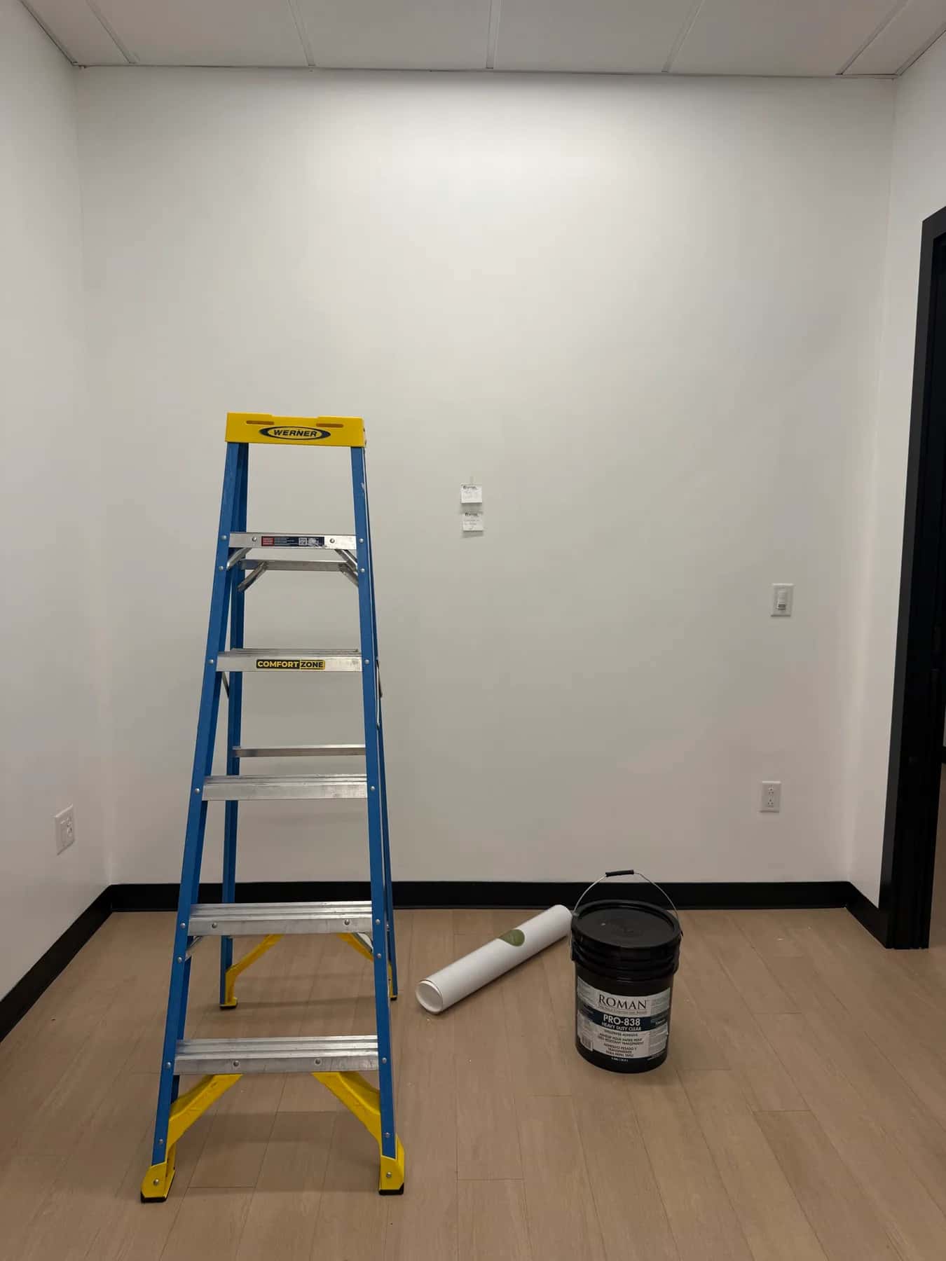 Stepladder, wallpaper roll and a bucket of paste in the empty suite before work began