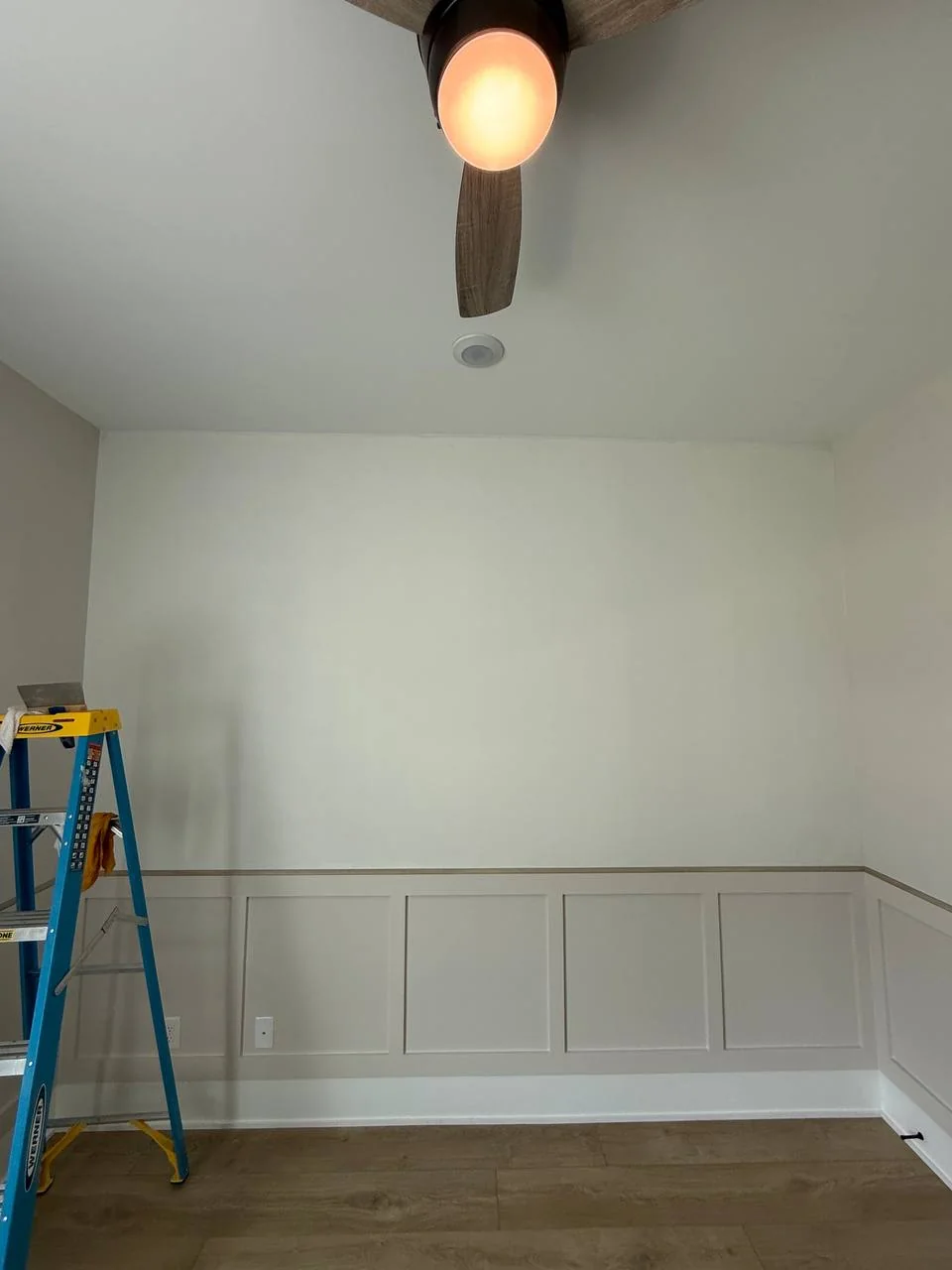 Bedroom accent wall before papering, plain paint