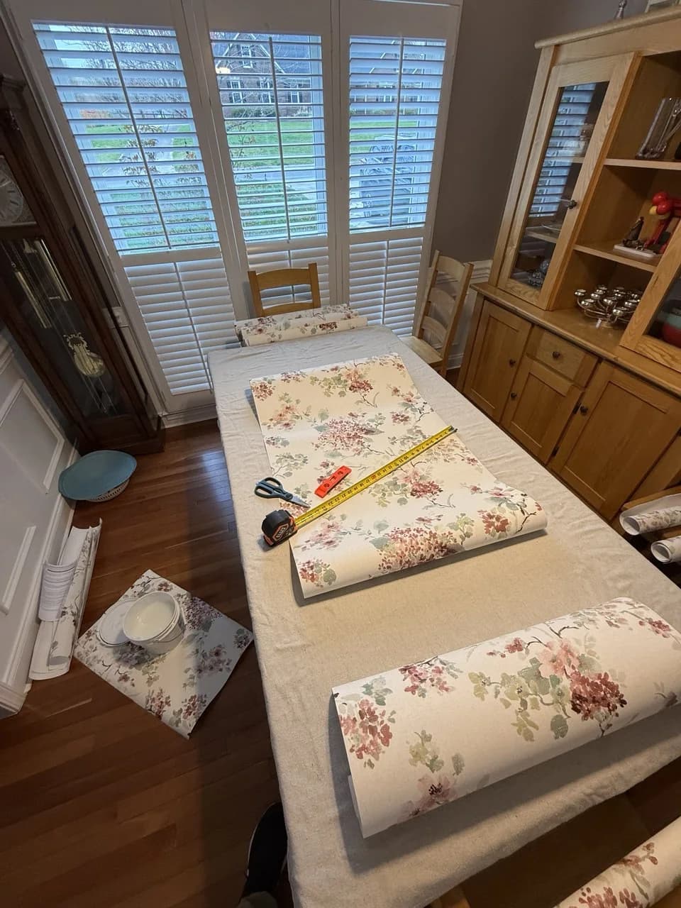 Measuring and trimming wallpaper on a pasting table