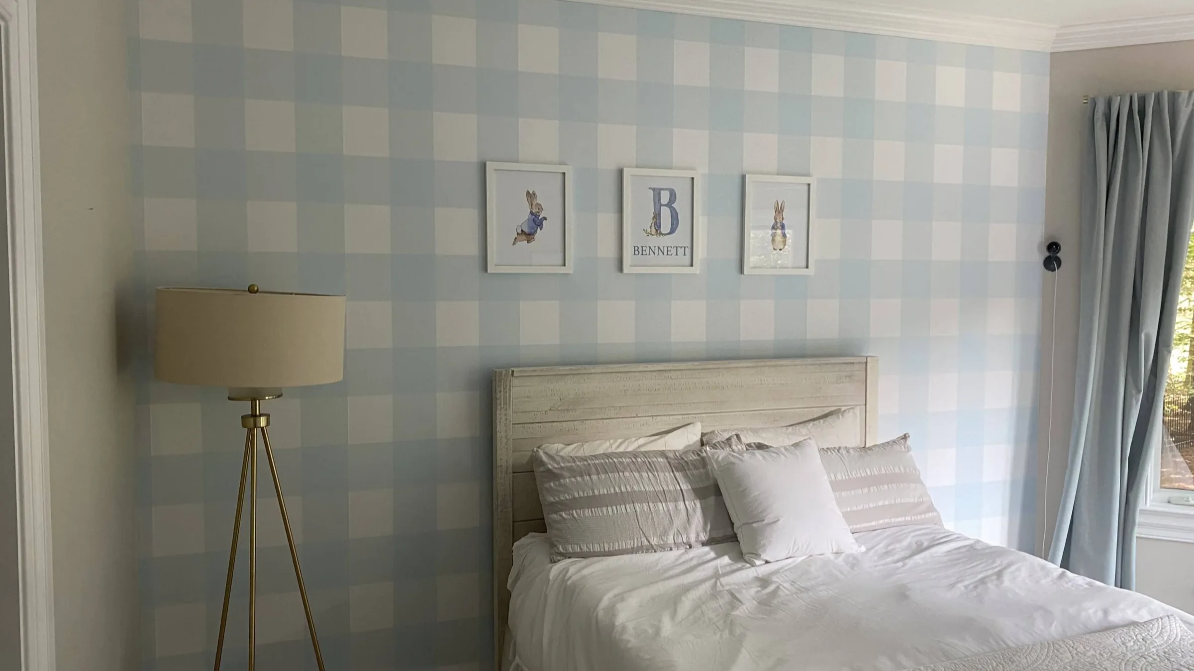 Soft blue plaid wallpaper behind a bed in a Charlotte bedroom