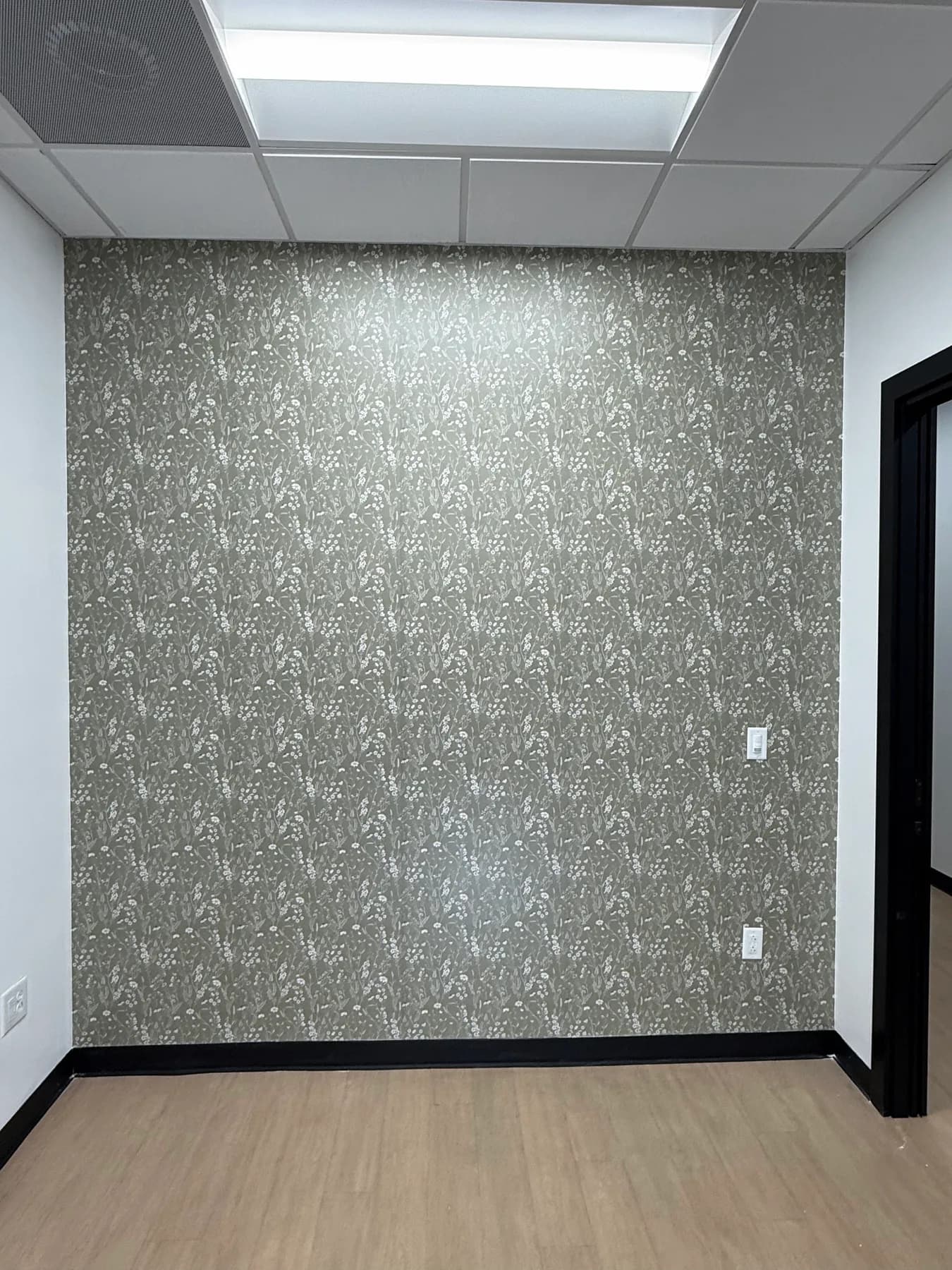 Sage green wildflower peel-and-stick wallpaper on one accent wall of a suite in Rock Hill, SC
